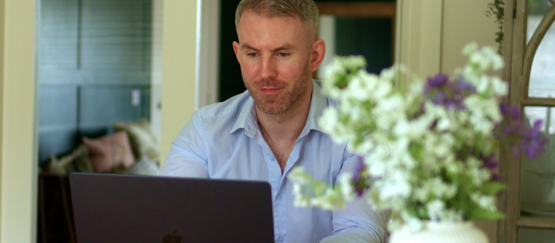 Conor Donaghey at home with a laptop, ready for an online therapy session